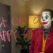 joker looks into a mirror with writing telling him to put on a happy face
